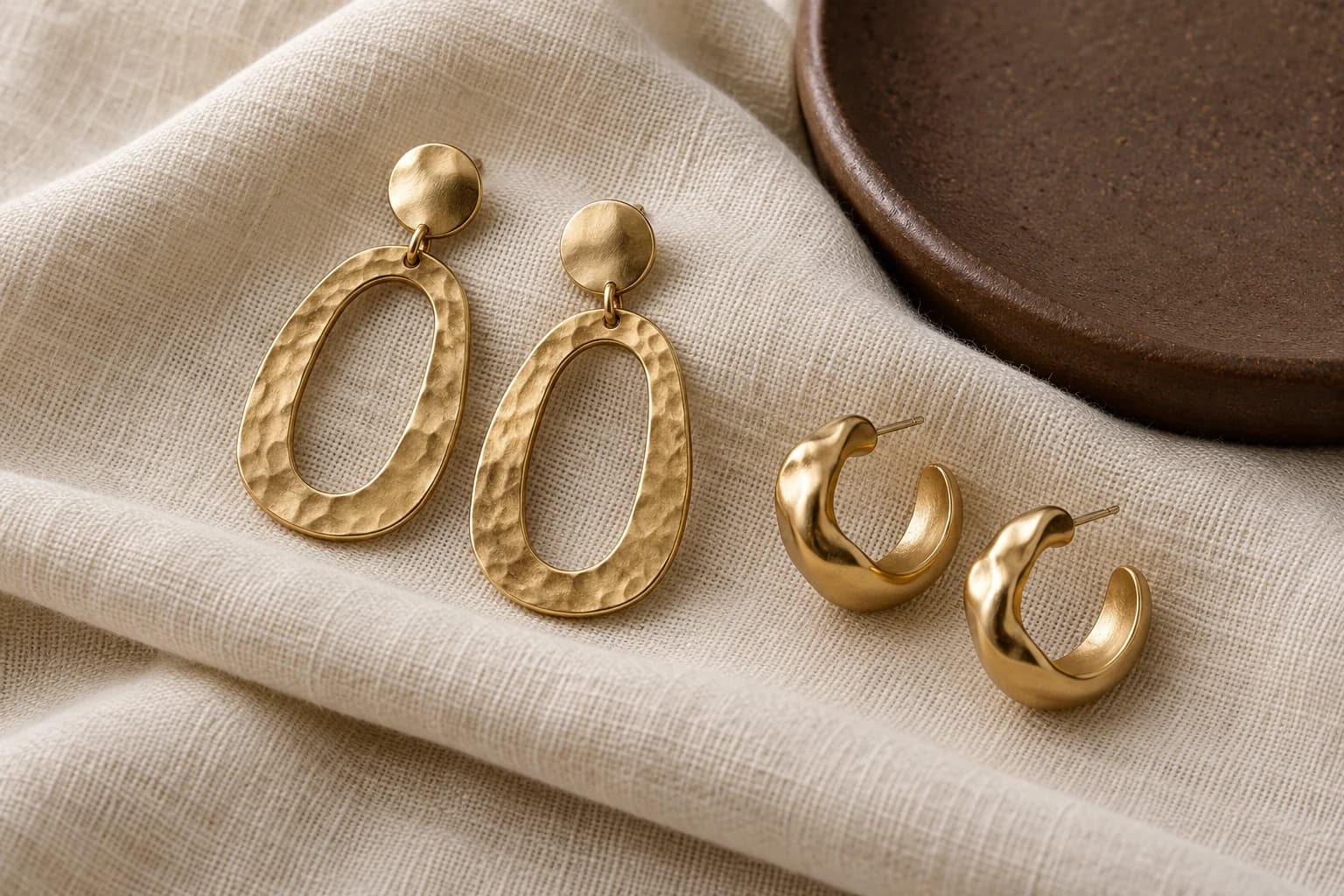 Product category: Gold-tone textured fashion earrings on pale fabric